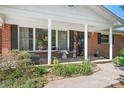 Inviting front porch with brick accents, offering a cozy outdoor seating area with plants and decorative touches at 3265 W Innes St, Salisbury, NC 28144