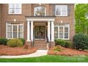 Charming front porch with brick steps, white columns, and decorative wreaths on double front doors at 4027 Wallbrook Dr, Matthews, NC 28105