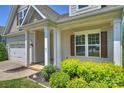 Up-close view of a well-kept home showcasing a cozy front porch with stately support columns at 505 Chamberlain Ct, McAdenville, NC 28101