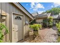 Inviting entrance featuring a quaint courtyard with brick pavers, potted plants, and a charming exterior door at 5306 Sandtrap Ln, Charlotte, NC 28226
