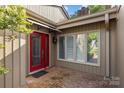 Welcoming front entrance with red door, brick pathway, and ample natural light from large windows at 5306 Sandtrap Ln, Charlotte, NC 28226