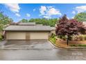 Spacious two-car garage with ample parking, surrounded by mature trees and landscaping at 5306 Sandtrap Ln, Charlotte, NC 28226