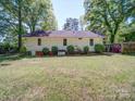 A view of the backyard showing the rear of the home and the surrounding lawn at 610 N Pine Ln, Wadesboro, NC 28170