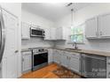 Well lit kitchen with stainless appliances, white cabinets and granite counters at 6101 Park Hill Rd, Charlotte, NC 28277