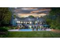 Luxury backyard with a pool, lounge chairs, and a covered patio, perfect for outdoor entertaining at 7912 Baltusrol Ln, Charlotte, NC 28210