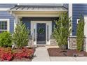 A beautifully landscaped front entrance with a decorative wreath, stone accents, and lush plantings at 8429 Golden Stone Ln, Fort Mill, SC 29707