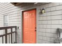 Front entry door featuring a unit number and light fixture with neutral-colored siding at 9029 J M Keynes Dr # 63, Charlotte, NC 28262