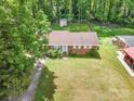 A charming brick home with a lush green lawn and mature trees at 907 E 9Th Ave, Gastonia, NC 28054