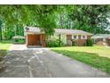 A well kept brick home with a lengthy driveway and lush green lawn at 907 E 9Th Ave, Gastonia, NC 28054