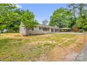A charming home with neutral paint, dark shutters, well-maintained lawn and convenient covered parking at 105 N Baldwin Ave, Kannapolis, NC 28083