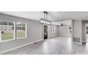 Bright, open-concept living space with light grey floors, modern lighting, and large windows at 11 Cobblestone Nw Ln, Concord, NC 28027