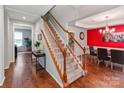 Home foyer with hardwood floors, staircase, and dining area featuring a tray ceiling and red accent wall at 11719 Withers Mill Dr, Charlotte, NC 28278