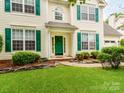 Attractive home featuring green shutters, an inviting entrance, and lovely landscaping. For Sale by Canopy2025 at 11719 Withers Mill Dr, Charlotte, NC 28278