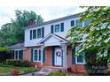 Charming two-story home with red brick facade, white siding, and vibrant landscaping at 1287 Queensgate St, Gastonia, NC 28054