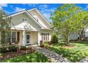 Inviting home featuring a charming facade, landscaped yard, and cozy front porch seating area at 13216 Old Compton Ct, Pineville, NC 28134