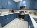Updated kitchen featuring blue cabinets, stainless steel appliances, and white countertops at 201 Mitchell St, Belmont, NC 28012