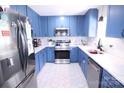 Bright kitchen featuring stylish blue cabinets, stainless steel appliances, and elegant white countertops at 201 Mitchell St, Belmont, NC 28012