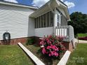 The cozy screened porch with white railings and vibrant pink azaleas, providing a perfect outdoor retreat at 201 Mitchell St, Belmont, NC 28012