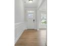 Bright foyer with decorative molding, front door, and wood flooring at 2020 Embassy Ct # 48, Charlotte, NC 28213