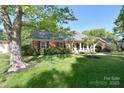 Traditional brick home with lush green lawn and mature shade trees at 317 Port Royal Dr, Matthews, NC 28105