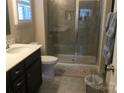Bathroom featuring shower with gray tile, glass doors, and dark wood vanity at 3173 Pinehills Way, Mount Holly, NC 28120