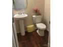 Cozy half bath with pedestal sink, wood-look flooring, and decorative accents at 3173 Pinehills Way, Mount Holly, NC 28120
