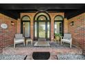Inviting brick front porch with stylish seating and arched windows flanking the front door at 3270 Kings Row Dr, Rock Hill, SC 29732