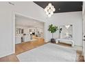 Bright, open foyer featuring hardwood floors, modern lighting, and a view into the living spaces at 3300 Sharon Rd, Charlotte, NC 28211