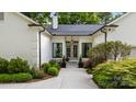 Elegant front entrance with manicured landscaping, a concrete walkway, and a sophisticated entry at 3300 Sharon Rd, Charlotte, NC 28211