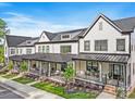 Row of white townhomes featuring inviting front porches and well-manicured landscaping at 360 N Broad St, Waxhaw, NC 28173