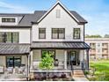 Charming white townhome with a covered front porch and landscaped yard, offering inviting curb appeal at 360 N Broad St, Waxhaw, NC 28173
