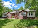 Charming brick and siding home with well-manicured lawn and lush landscaping on a sunny day at 4301 Middle Stream Rd, Charlotte, NC 28213