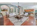 Bright living room with hardwood floors, modern furniture, and an open layout leading to the kitchen at 4301 Middle Stream Rd, Charlotte, NC 28213