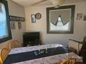 Cozy dining room with a floral tablecloth, natural light from the windows, and adjacent TV for easy entertainment at 4671 Lucas Ct, Harrisburg, NC 28075