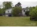 Cozy home with a simple facade, surrounded by greenery and featuring a modest front porch and yard at 4671 Lucas Ct, Harrisburg, NC 28075