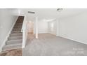 Bright and airy living room with neutral carpet and staircase at 5030 Ashley Place Dr, Bessemer City, NC 28016