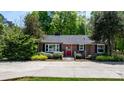 Quaint brick ranch-style home with a red door and black shutters, nestled in a green landscape at 536 Hartness Rd, Statesville, NC 28677
