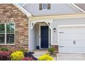 Stylish front entrance with a blue door, stone accents, and manicured flower beds at 536 Rustlewood Way, Rock Hill, SC 29732
