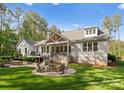 Backyard with a stone patio, fire pit, outdoor seating, and a covered porch at 7351 Bay Cove Ct, Denver, NC 28037