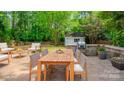 Outdoor dining area in backyard with spacious patio, stone grill, and ample seating at 7810 Trotter Rd, Charlotte, NC 28216