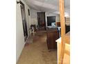 Room featuring a dark doorway, tan carpeting, and an assortment of stacked furniture and boxes at 908 E 1St St, Newton, NC 28658