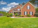 Charming two-story brick home featuring manicured landscaping and an inviting front porch at 914 Olive Mill Ln, Matthews, NC 28104