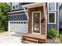 The front porch has a modern wood door with glass, side-light windows and a two-car garage at 933 Tennyson Dr, Charlotte, NC 28208
