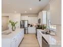 Spacious kitchen with white cabinets, stainless steel appliances, and a large central island with quartz countertops at 103 White Apple Way, Statesville, NC 28625