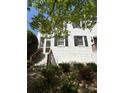 White brick home with dark shutters, surrounded by greenery and a brick staircase at 119 N Laurel Ave # 1, Charlotte, NC 28207