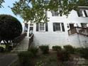 View of the front of the house with dark shutters and white brick, surrounded by greenery at 119 N Laurel Ave # 1, Charlotte, NC 28207