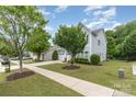 Two-story home with gray siding, a two-car garage, a long driveway, and a manicured lawn and landscaping at 1210 Gold Rush Ct, Fort Mill, SC 29708