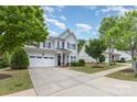 Two-story home featuring gray siding, black shutters, dormer windows, a two-car garage, and a long driveway at 1210 Gold Rush Ct, Fort Mill, SC 29708