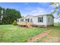 A cozy single-story home featuring a wooden front deck and a spacious yard at 125 Rocky Pt, Cleveland, NC 27013