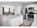 Kitchen showcasing stainless steel appliances, white cabinets, granite counters, and an open view to the living room at 128 Millstream Dr, China Grove, NC 28023